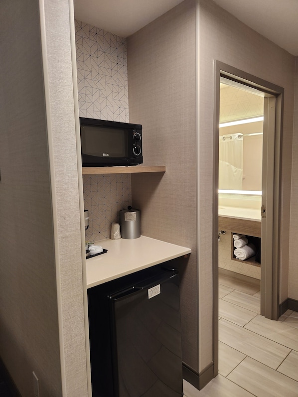 A compact kitchenette with a microwave, a small refrigerator, and a sink. - Holiday Inn Express Hotel & Suites Crawfordsville by IHG (Crawfordsville)