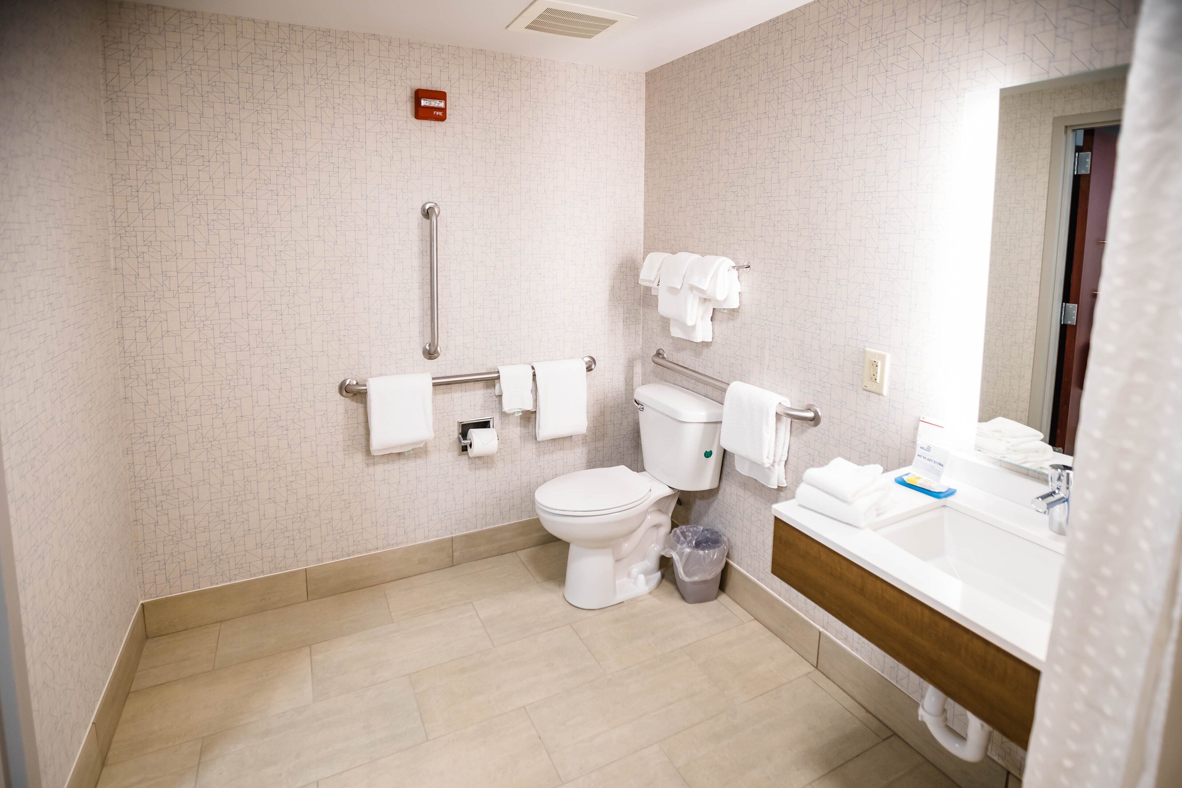 Un baño moderno con inodoro, bidé, secamanos y lavamanos.