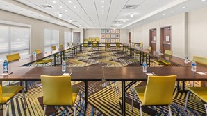 A conference room with a long table, yellow chairs, and a patterned carpet. - Holiday Inn Express & Suites Willows by IHG (Willows)