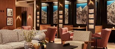 A modern interior with a wooden ceiling, bookshelves, and seating areas.