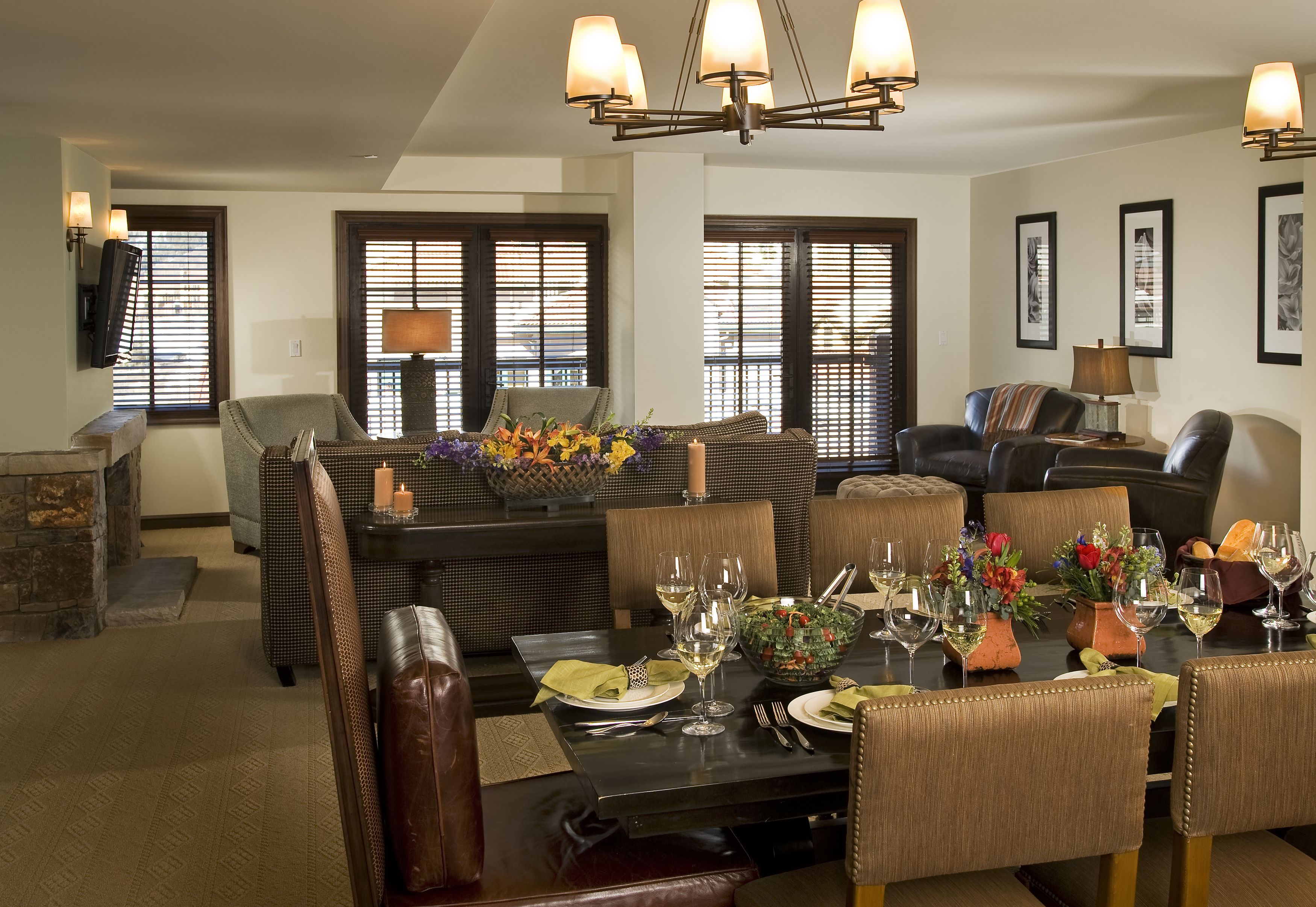 A dining area with a dark wooden table set for four, surrounded by upholstered chairs.