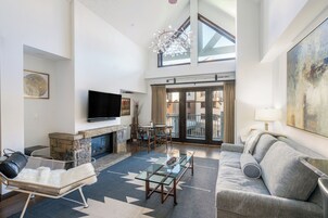 A spacious living room with a fireplace, a flat-screen TV, a sofa, and a dining area with a table and chairs.