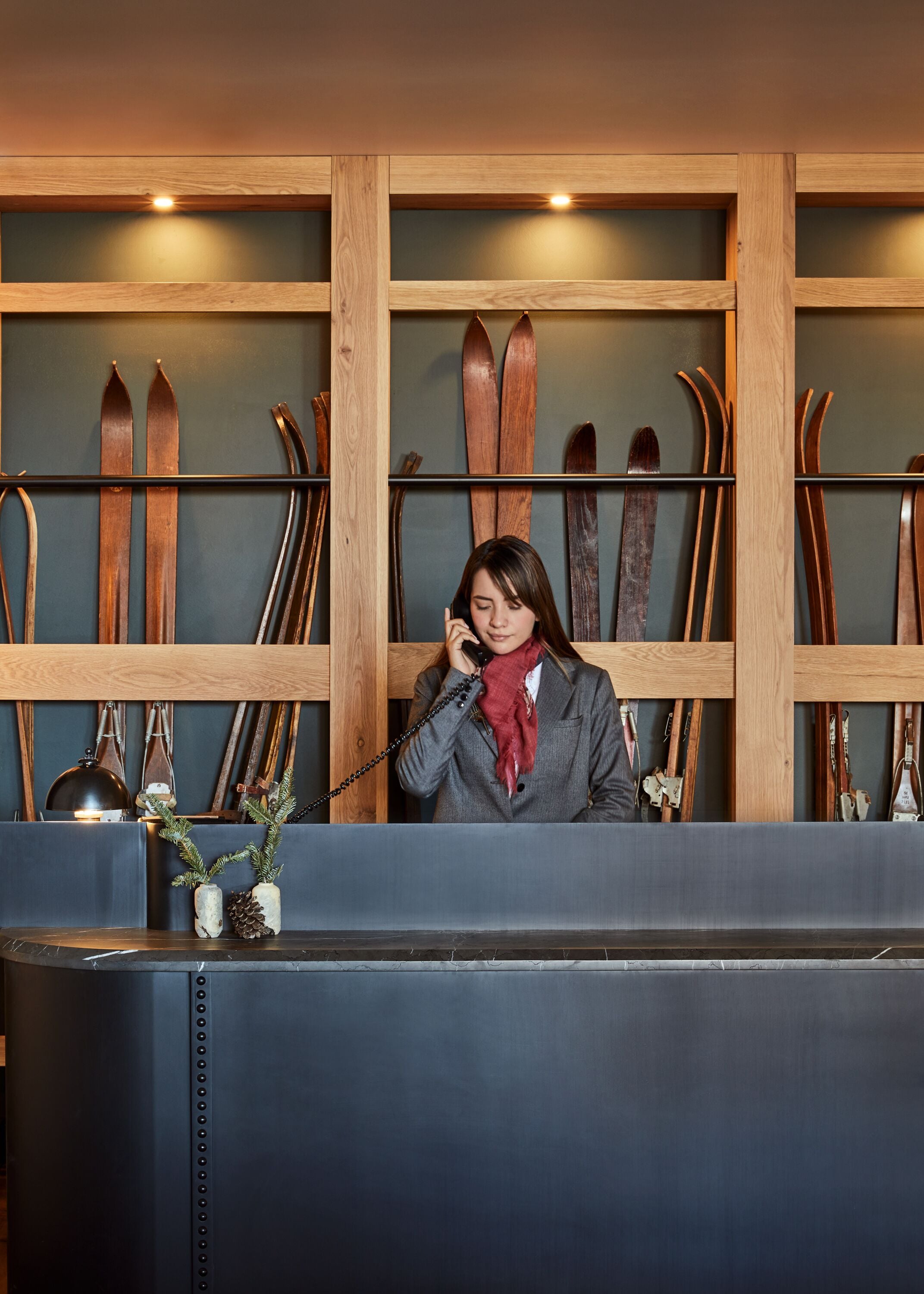 A reception desk with skis in the background.