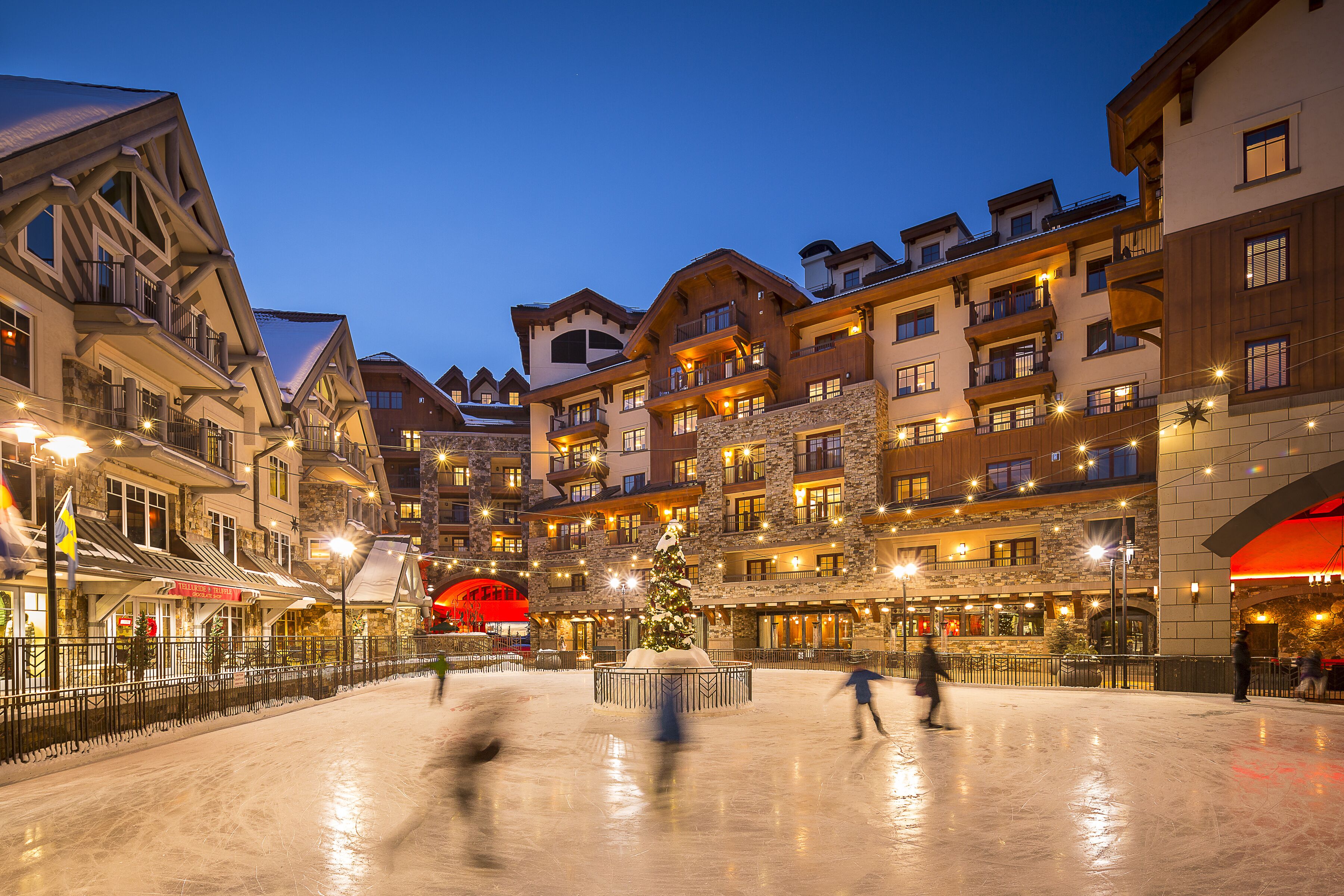 Un hotel de varios pisos con balcones y una pista de hielo central.