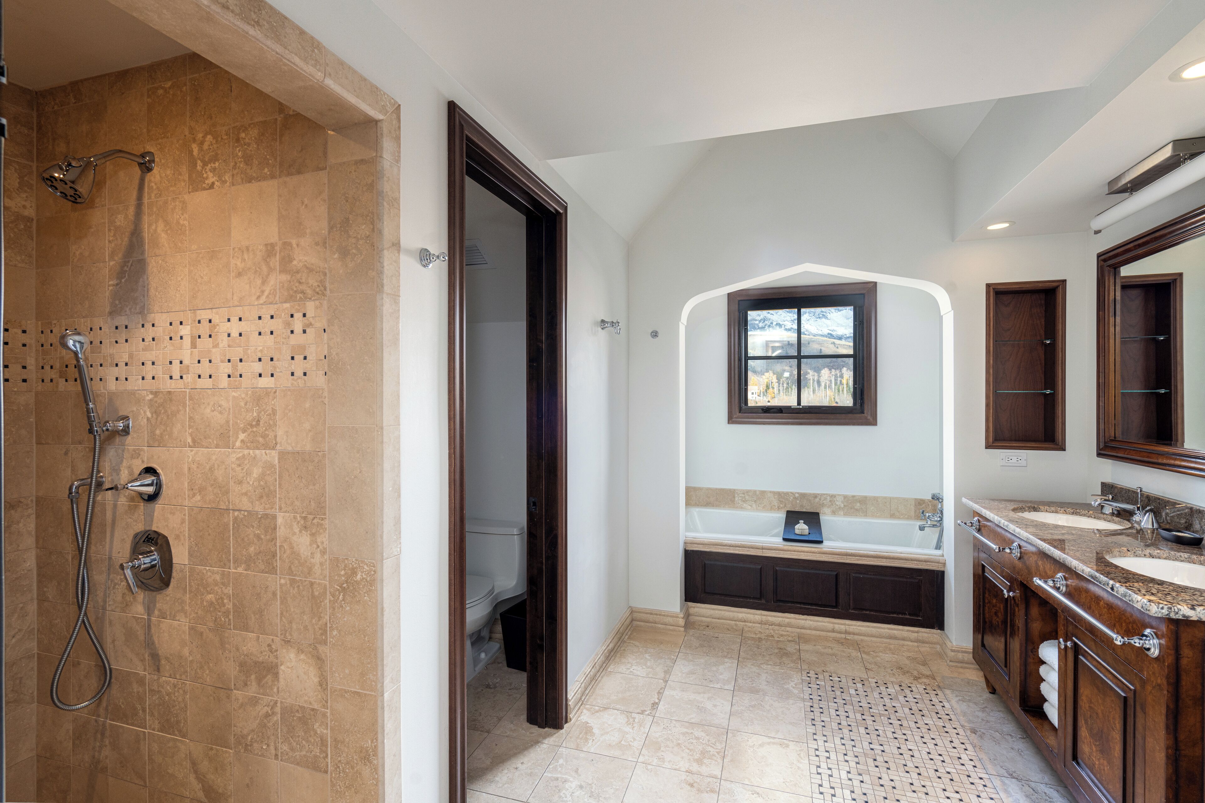 A spacious bathroom with a walk-in shower, a freestanding bathtub, and a vanity with a large mirror.