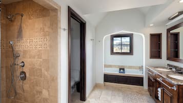 A spacious bathroom with a walk-in shower, a freestanding bathtub, and a vanity with a large mirror.