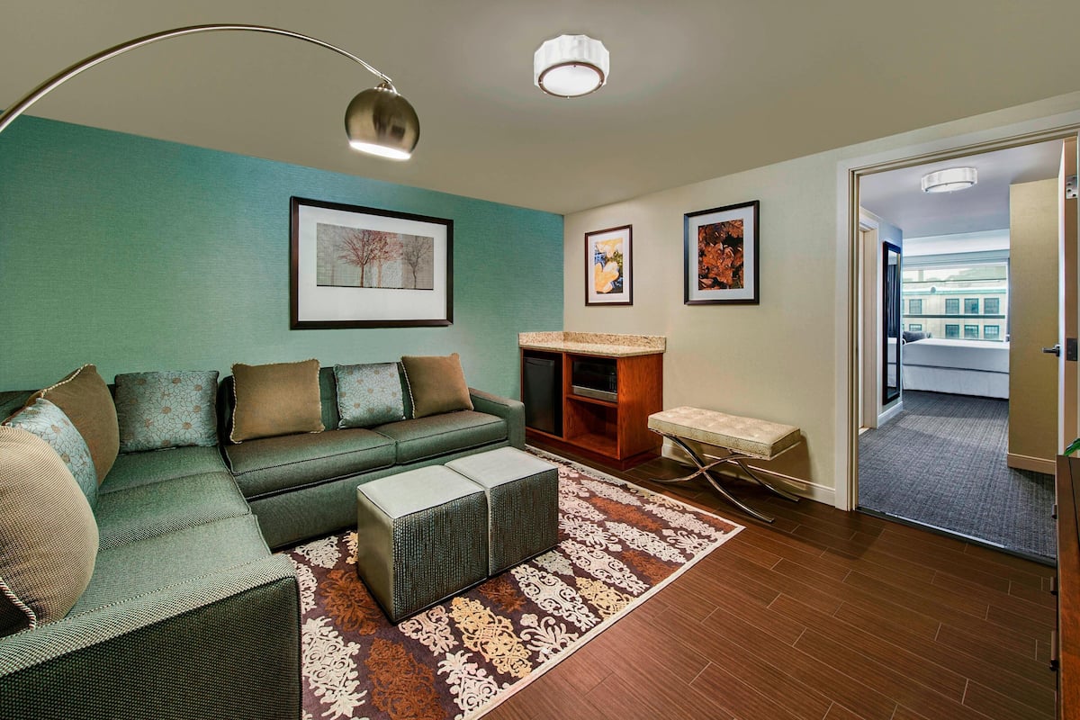A living room with a sectional sofa, a coffee table, a rug, and framed artwork on the walls.