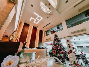 A modern hotel lobby with a Christmas tree, a reception desk, and a large window offering a view of the city. - P2 Boutique Hotel (Bangkok)