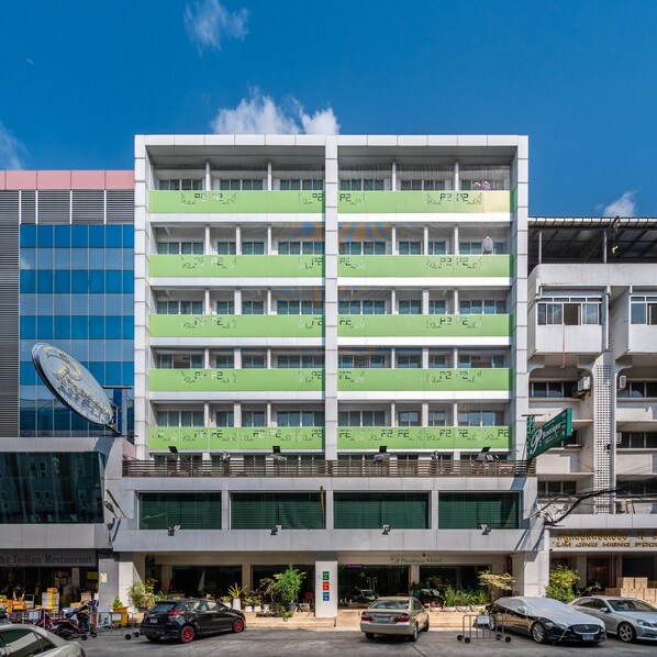 A multi-story hotel with a green facade, multiple floors, and a parking area in front. - P2 Boutique Hotel (Bangkok)