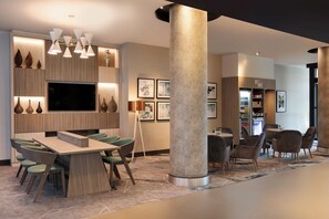 Relax in our spacious lobby with a central seating area, large TV, and decorative vases.