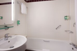 Bathroom features a bathtub, sink, and large mirror.