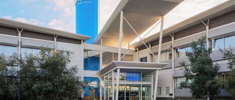 A modern building with a prominent blue tower and a covered entrance labeled 'mantra.'