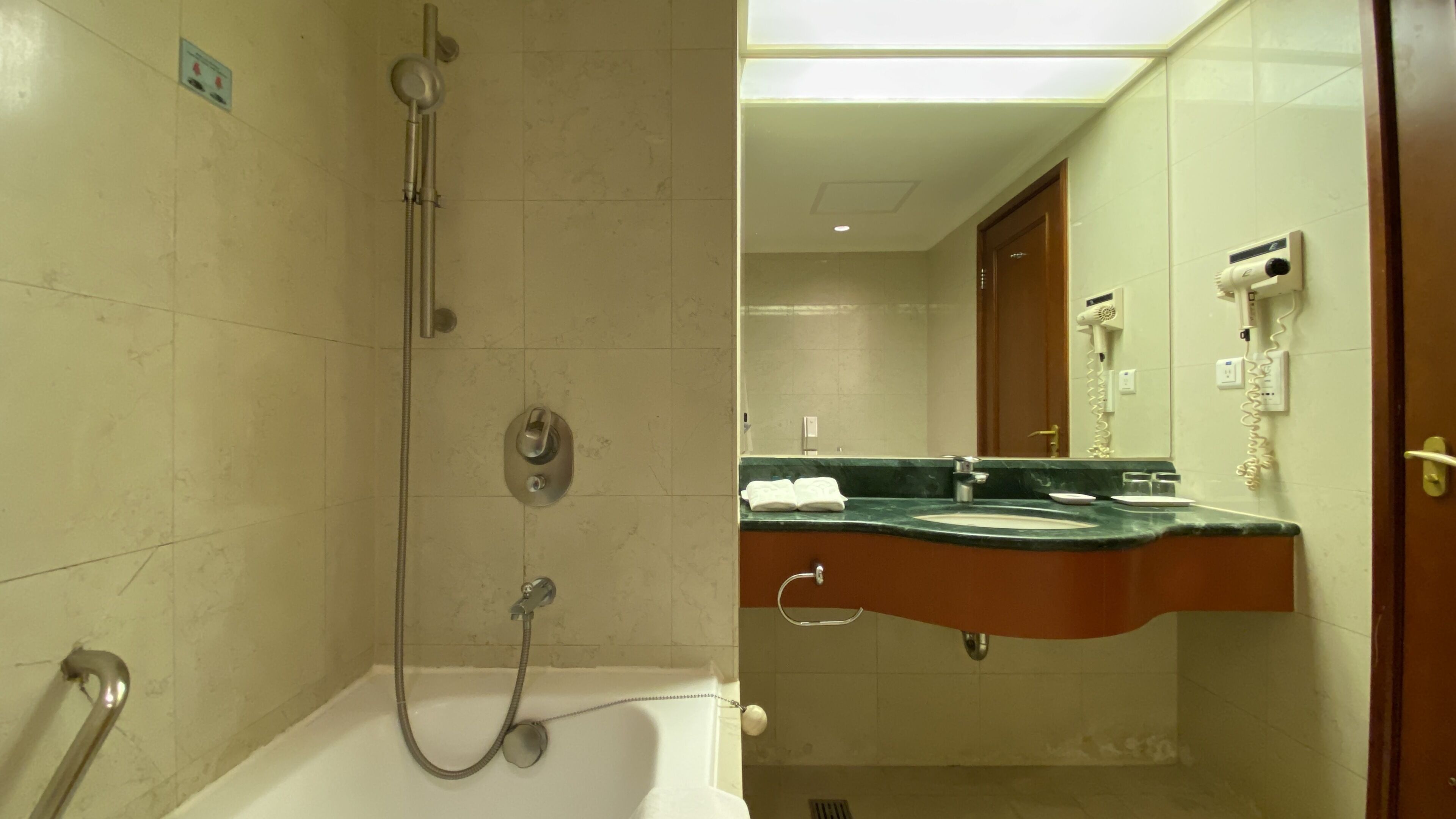 Un baño con bañera, ducha, lavabo y espejo.