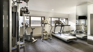 A gym with cardio machines, weight equipment, and large windows. - Causeway 353 Hotel (Melbourne)