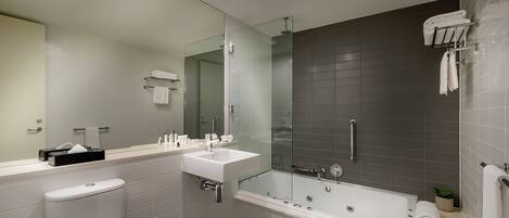 Une salle de bain moderne équipée de toilettes, d’un lavabo et d’une baignoire.
