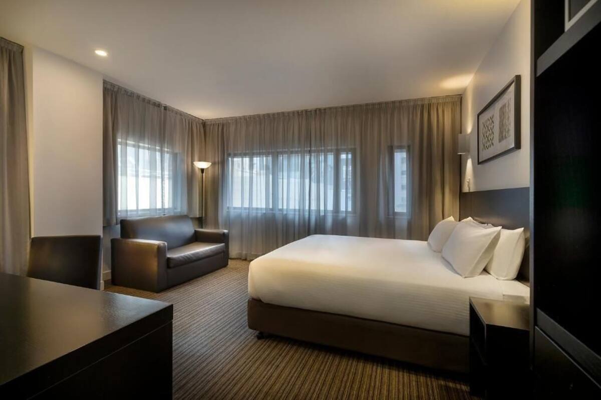 Une chambre d’hôtel avec un grand lit, un canapé, un bureau et une télévision.