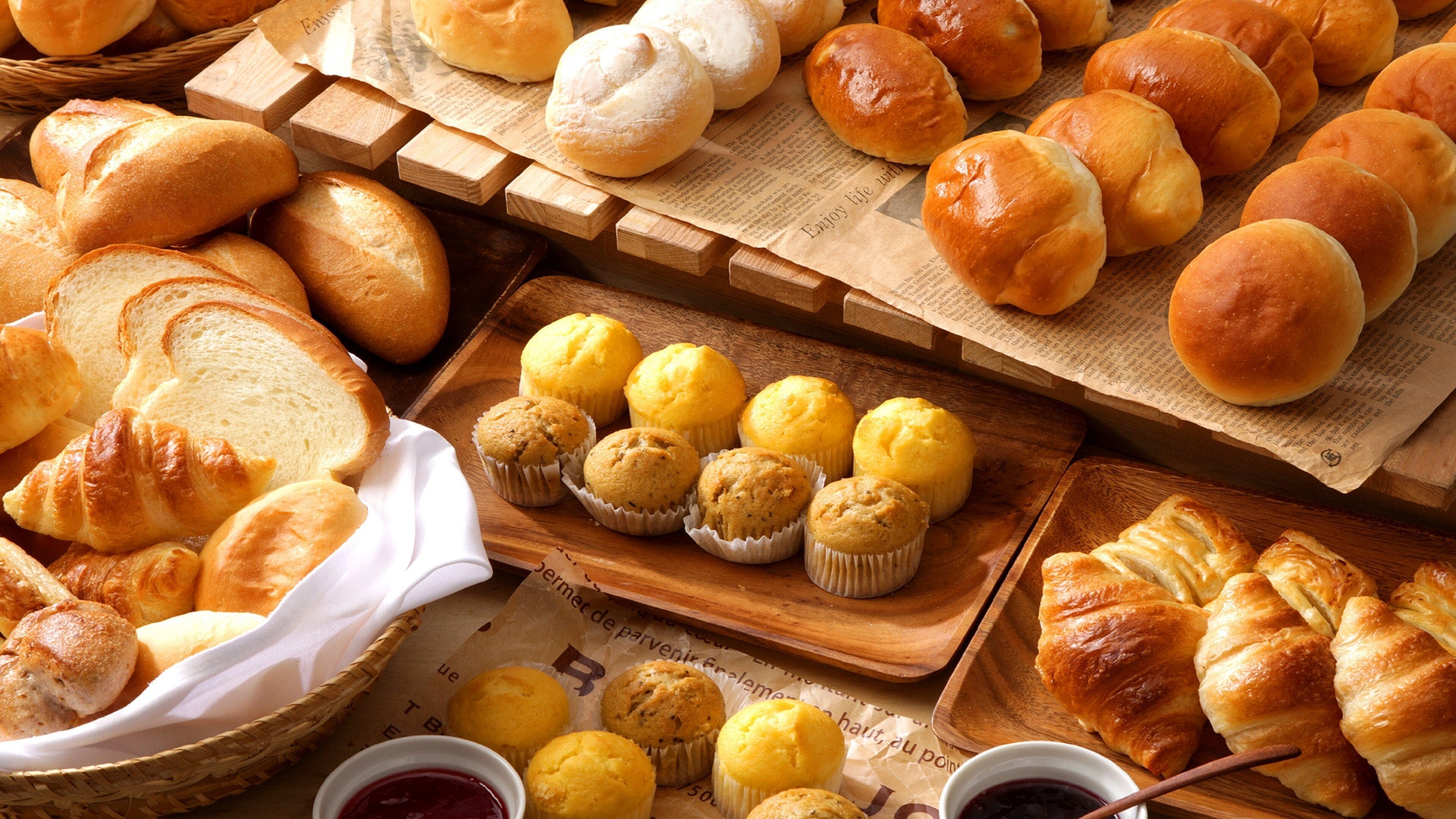 Diversos produtos de panificação, incluindo pão, muffins e croissants.