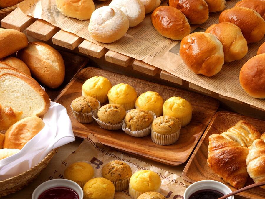 Diversos produtos de panificação, incluindo pão, muffins e croissants.