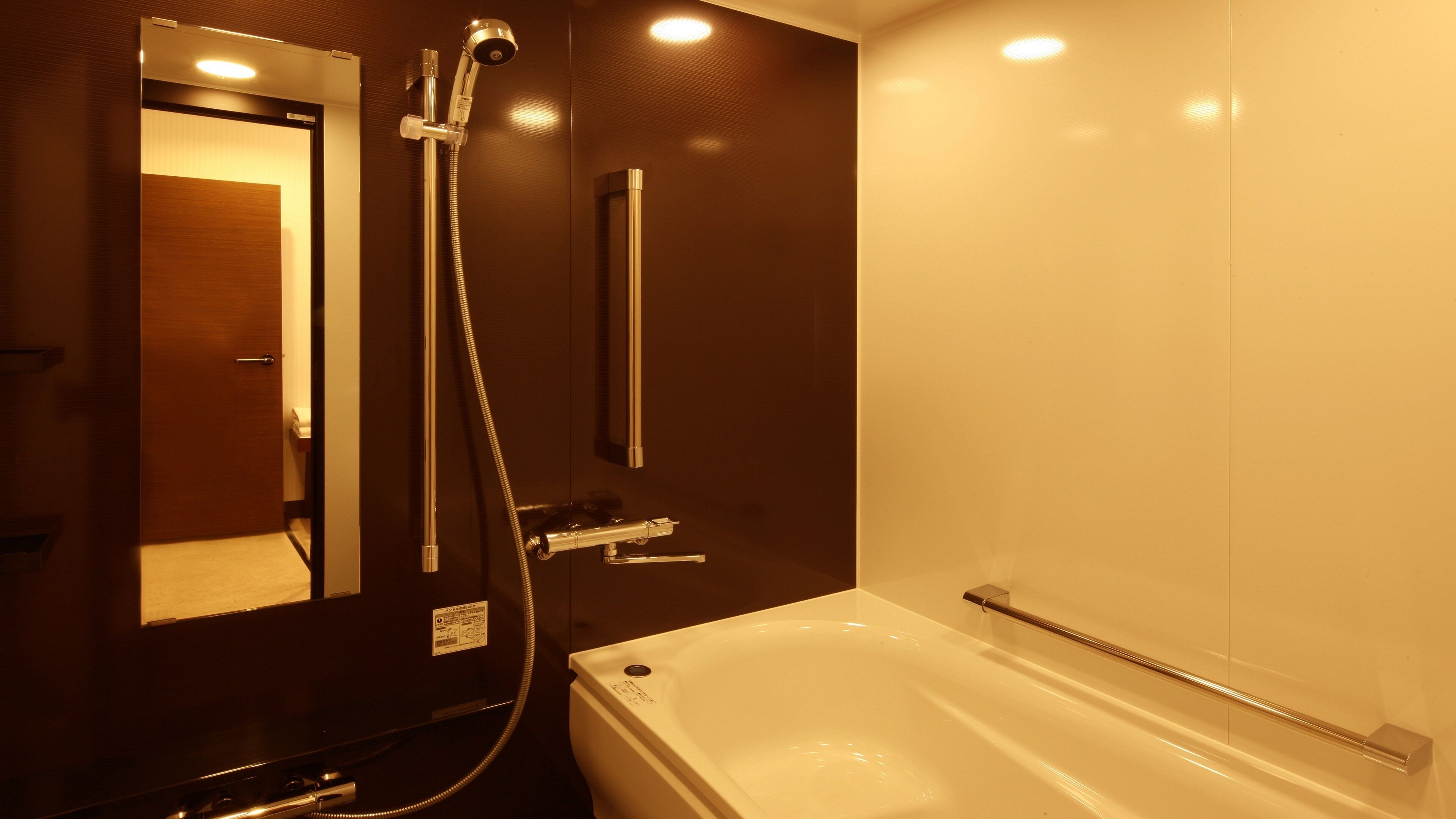 A bathroom with a bathtub, a shower, and a mirror.