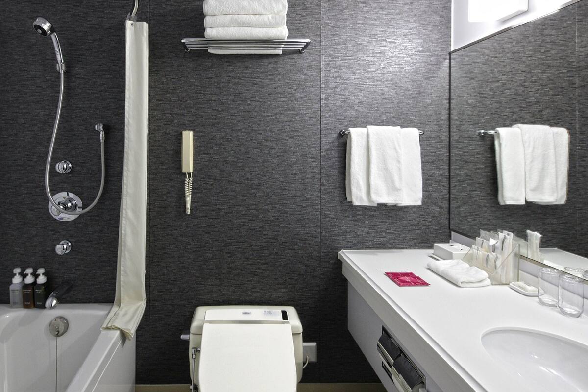 Ein modernes Badezimmer mit Badewanne, Dusche, Toilette und Waschbecken.