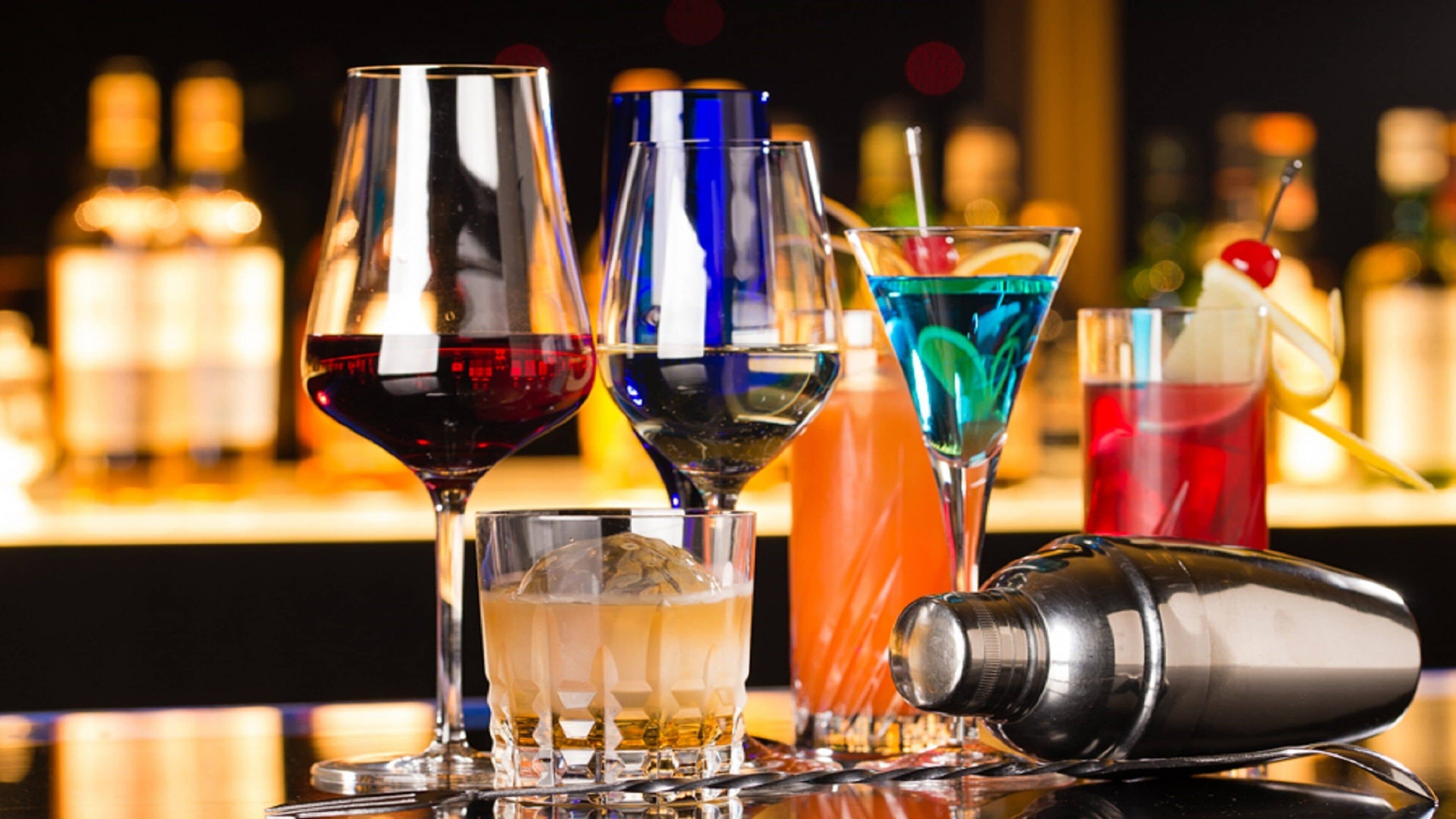 A bar setting with various glasses and bottles.