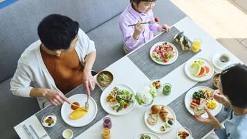 A dining table with various dishes, including salads, rice, and a croissant.