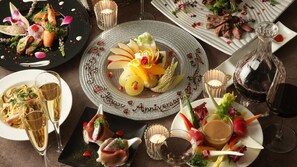 Une table dressée avec divers plats, notamment des fruits de mer, des fruits et une assiette de desserts portant le message « Joyeux anniversaire ».