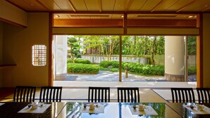 Une salle de conférence donnant sur un jardin aménagé grâce à de grandes fenêtres.