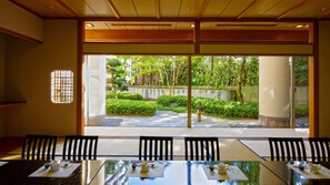 A conference room with a view of a landscaped garden through large windows. - ANA Crowne Plaza Niigata by IHG (Niigata)
