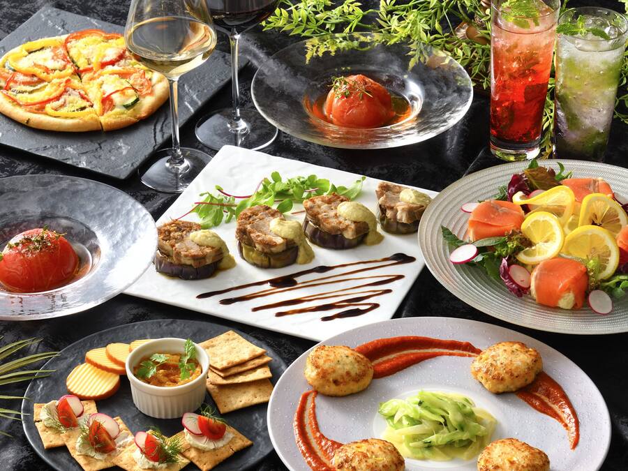A variety of dishes including pizza, a tomato-based dish, and a salad with salmon and vegetables.