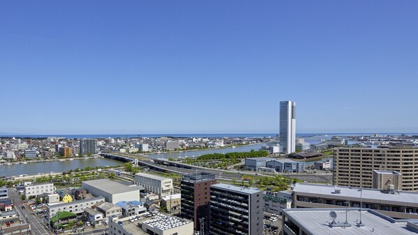 Une vue urbaine mettant en scène un gratte-ciel moderne imposant, une rivière et un pont.