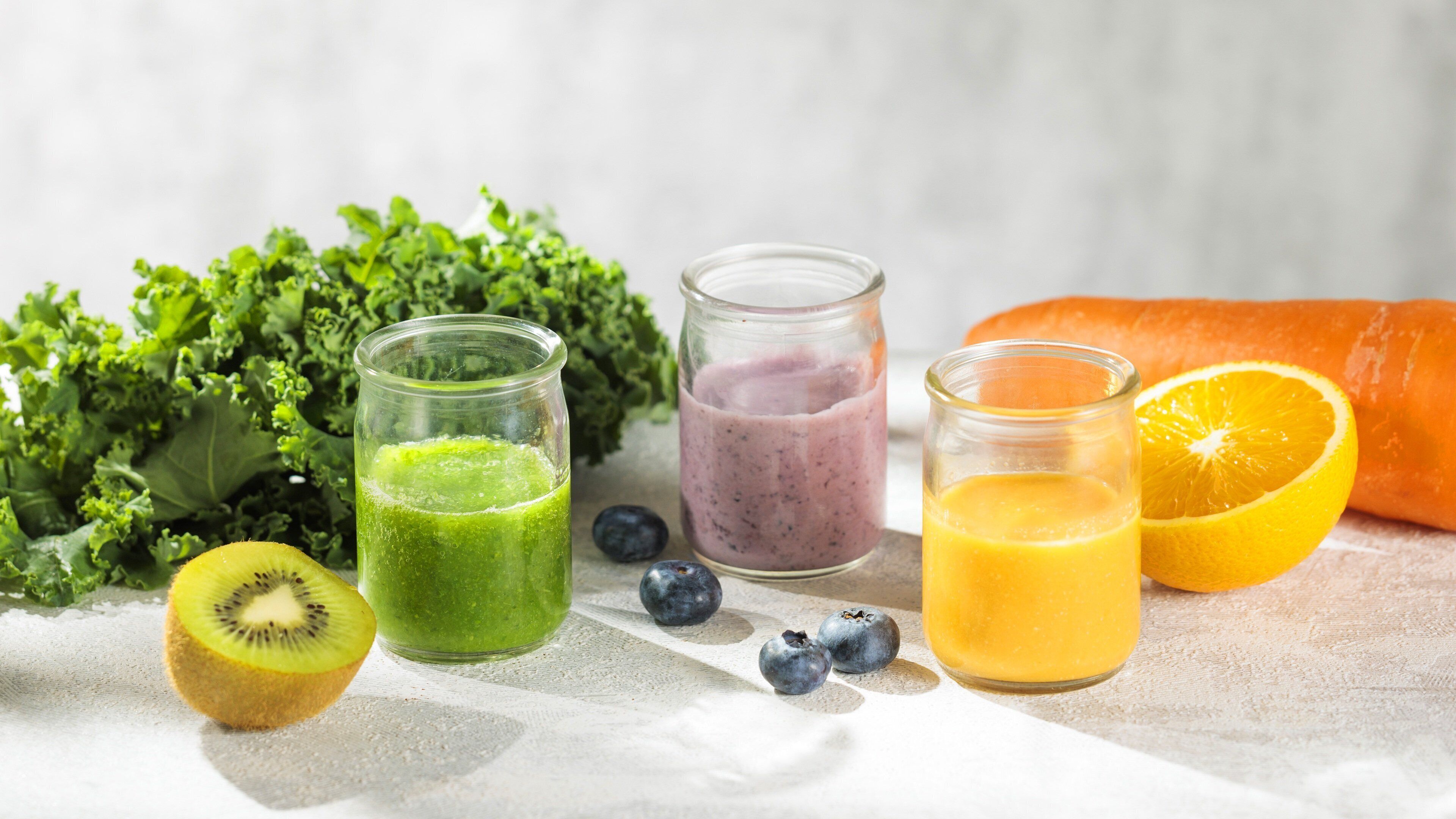 A variety of fresh fruits and smoothies on a table.