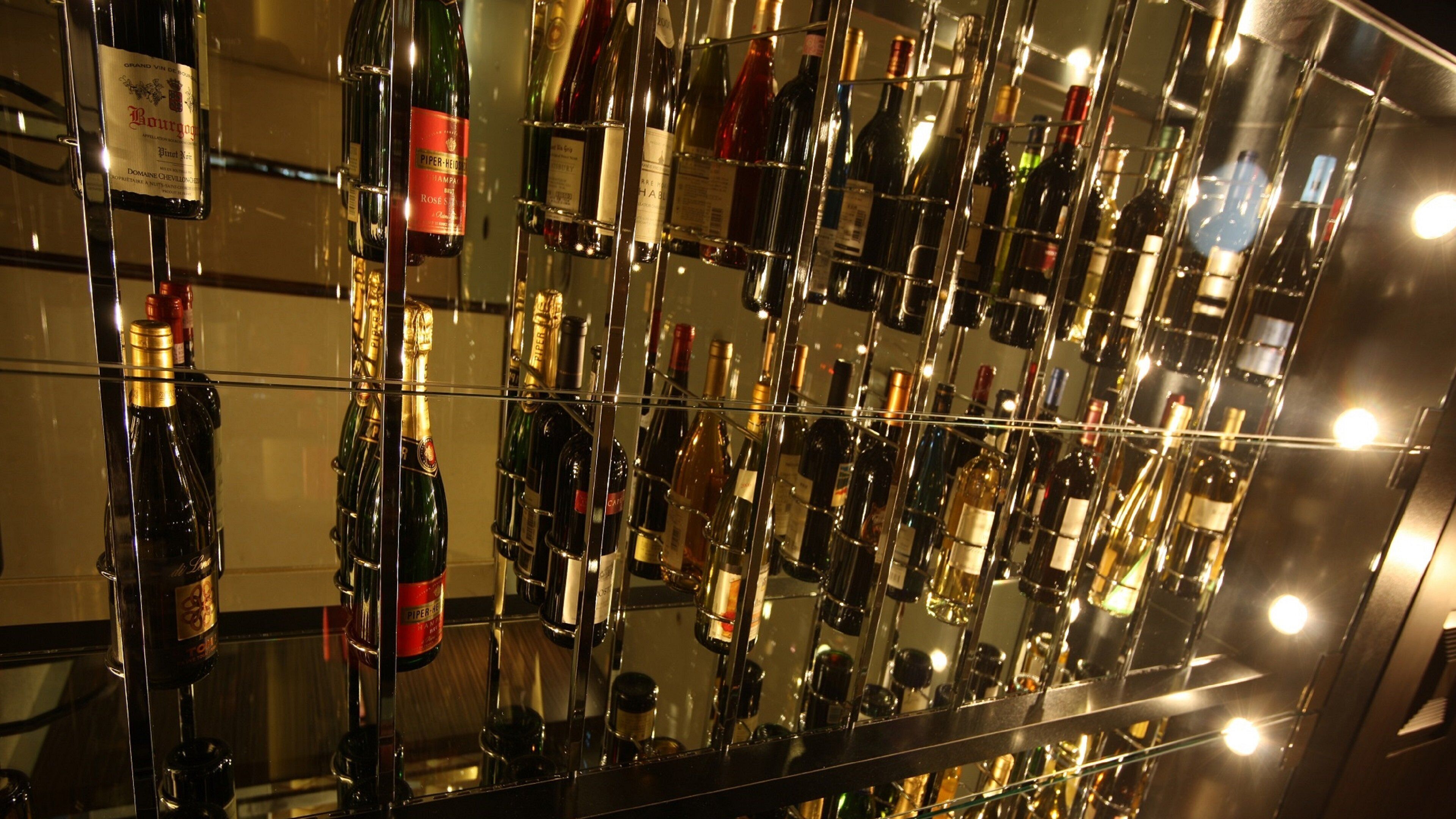 A mirrored wall with various bottles of wine and champagne.