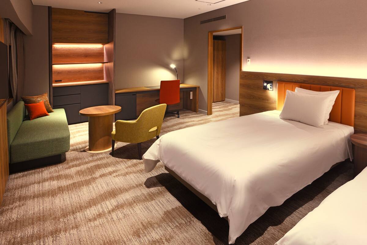 Ein Hotelzimmer mit einem großen Bett, einer Sitzecke, einem Schreibtisch und einem Sessel.