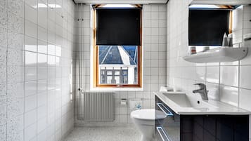 A compact bathroom with a toilet, sink, and window.