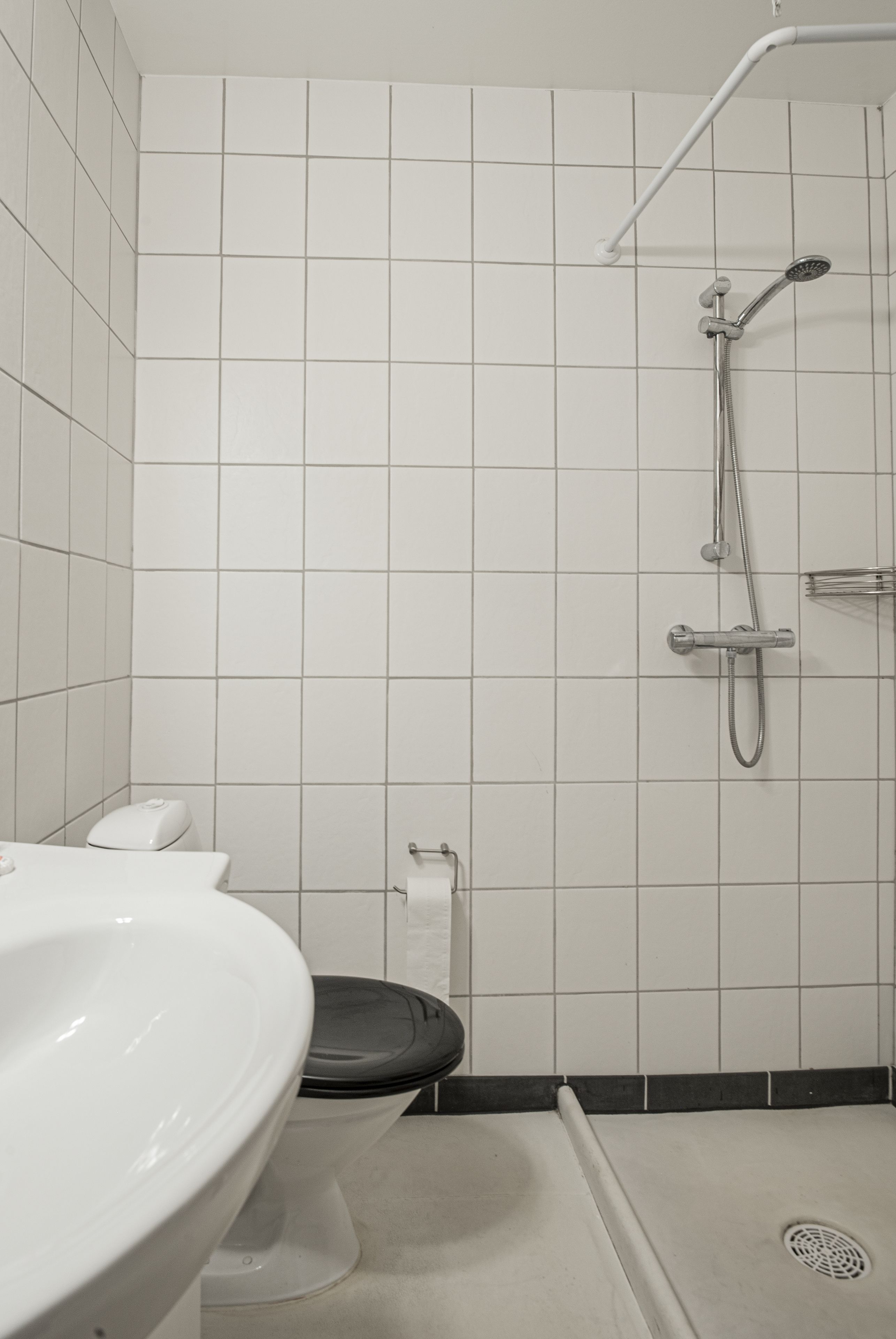A bathroom with a white sink, toilet, and shower.