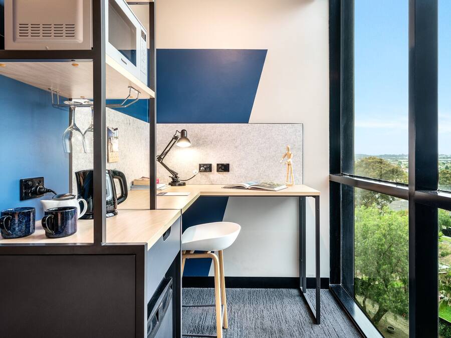 Un espacio de oficina moderno con escritorio, silla y cafetera.