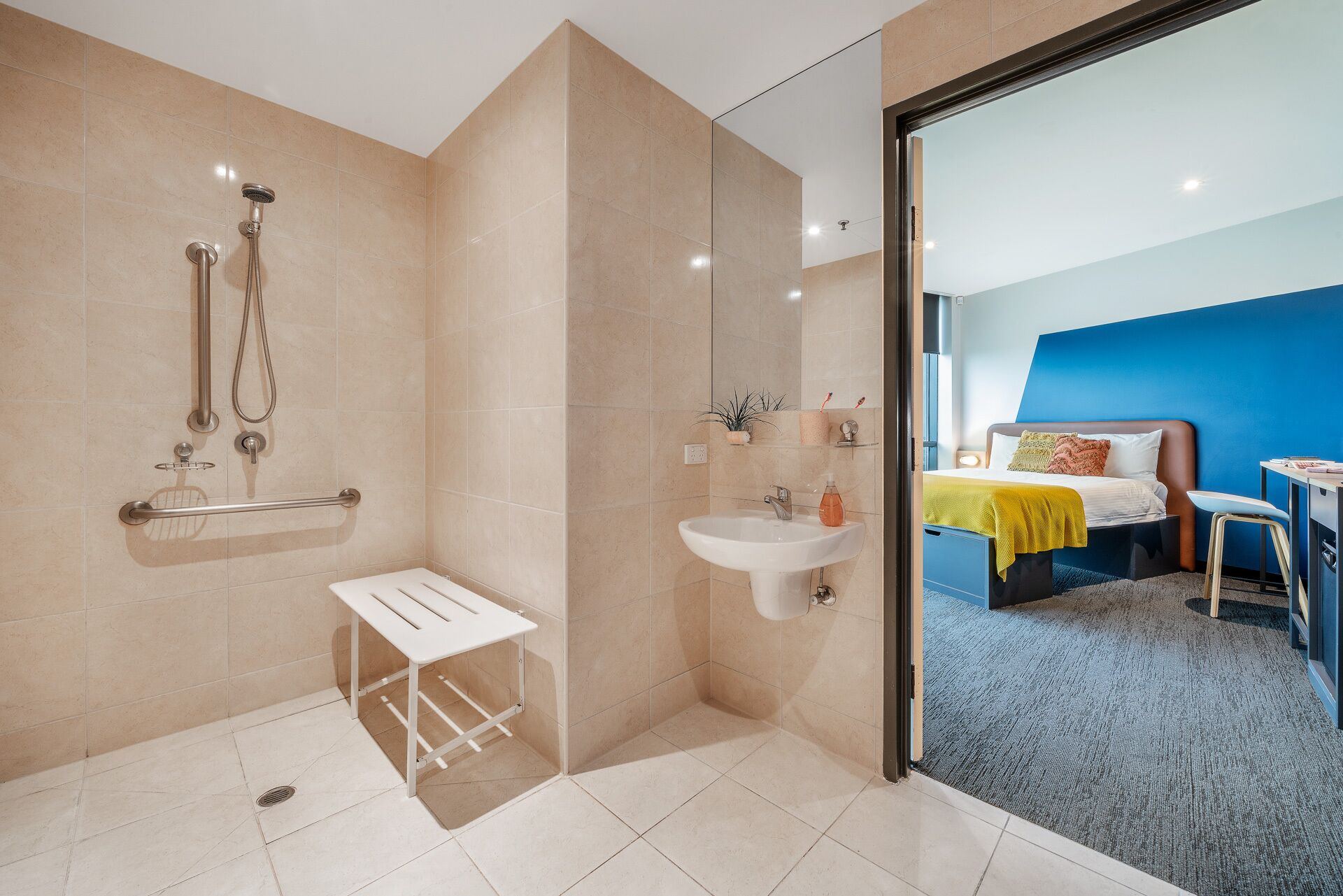 A modern bathroom with a shower, sink, and a small table.
