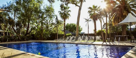 Una piscina al aire libre, sombrillas