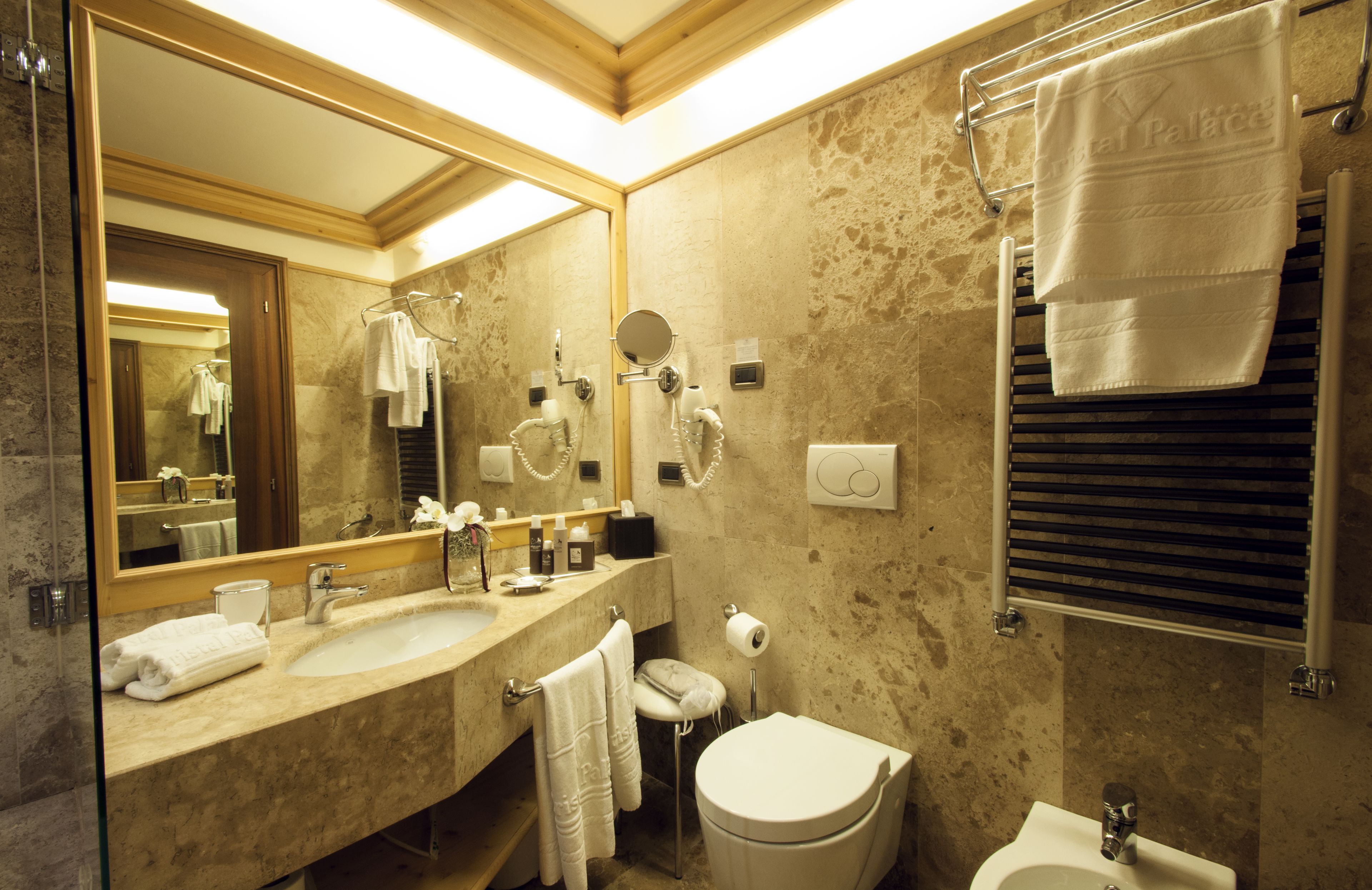 A bathroom with two sinks, a toilet, a mirror, and a towel rack.