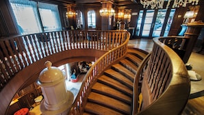 A grand wooden staircase with a balustrade, leading to a lower level. - Cristal Palace (Pinzolo)