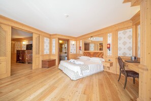 Cozy retreat with a large bed, wooden desk, and mirror.