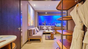 A modern spa room with a sofa, a small table, a wooden bench, and an aquarium. - Hotel H2O (Manila)