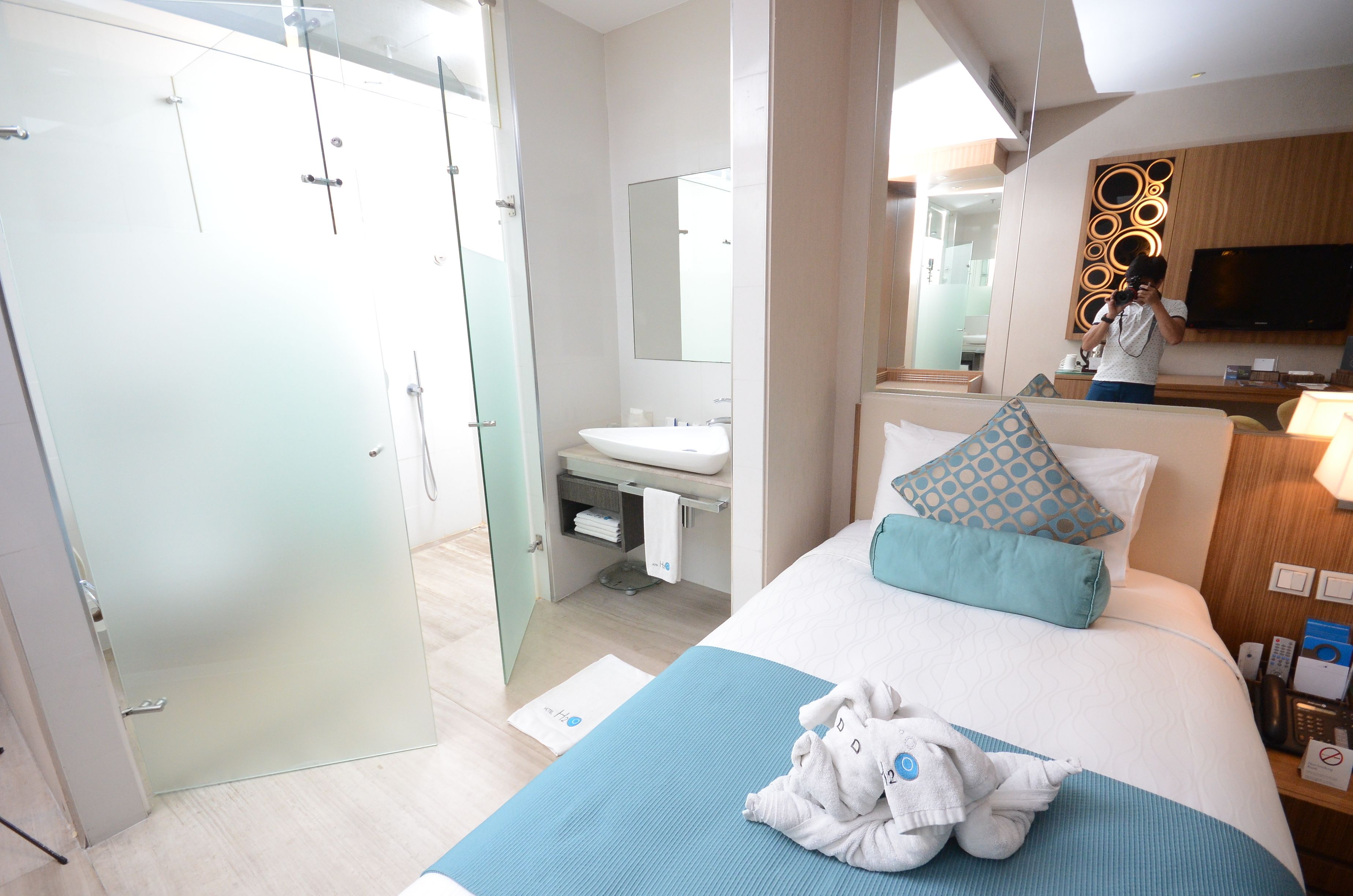 A hotel room with a bed, a bathroom, and a TV.