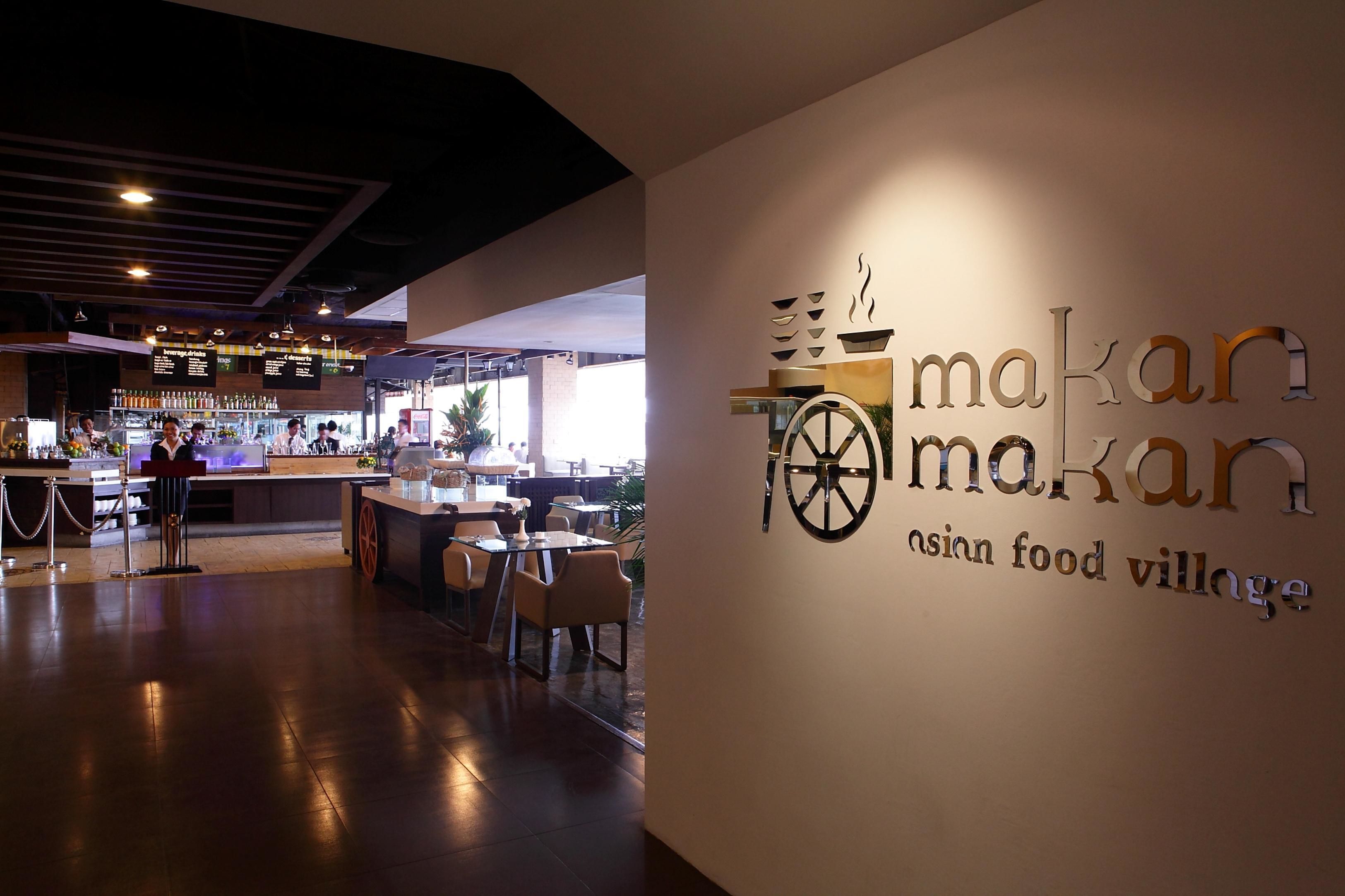 Un interior de restaurante con una zona de bar, mesas y sillas.
