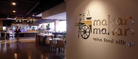 Un interior de restaurante con una zona de bar, mesas y sillas.