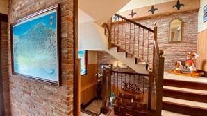 Un escalier avec une rampe en bois et un mur en briques.