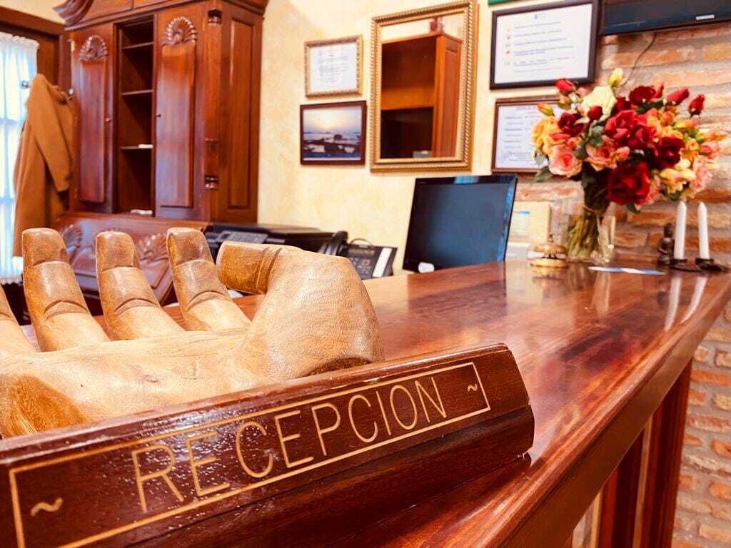 A reception desk with a wooden nameplate reading "RECEPTION".