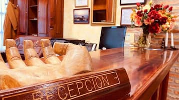 A reception desk with a wooden nameplate reading "RECEPTION".