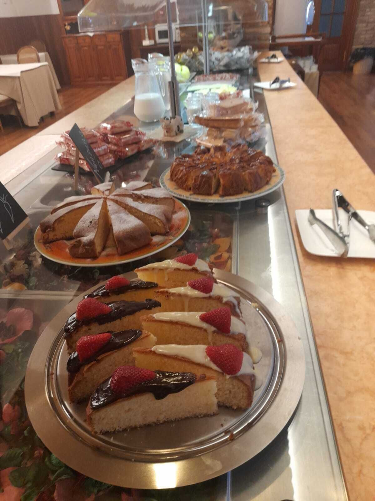 Een buffet met diverse desserts, waaronder een taart met aardbeien en chocolade, en andere gebakjes.